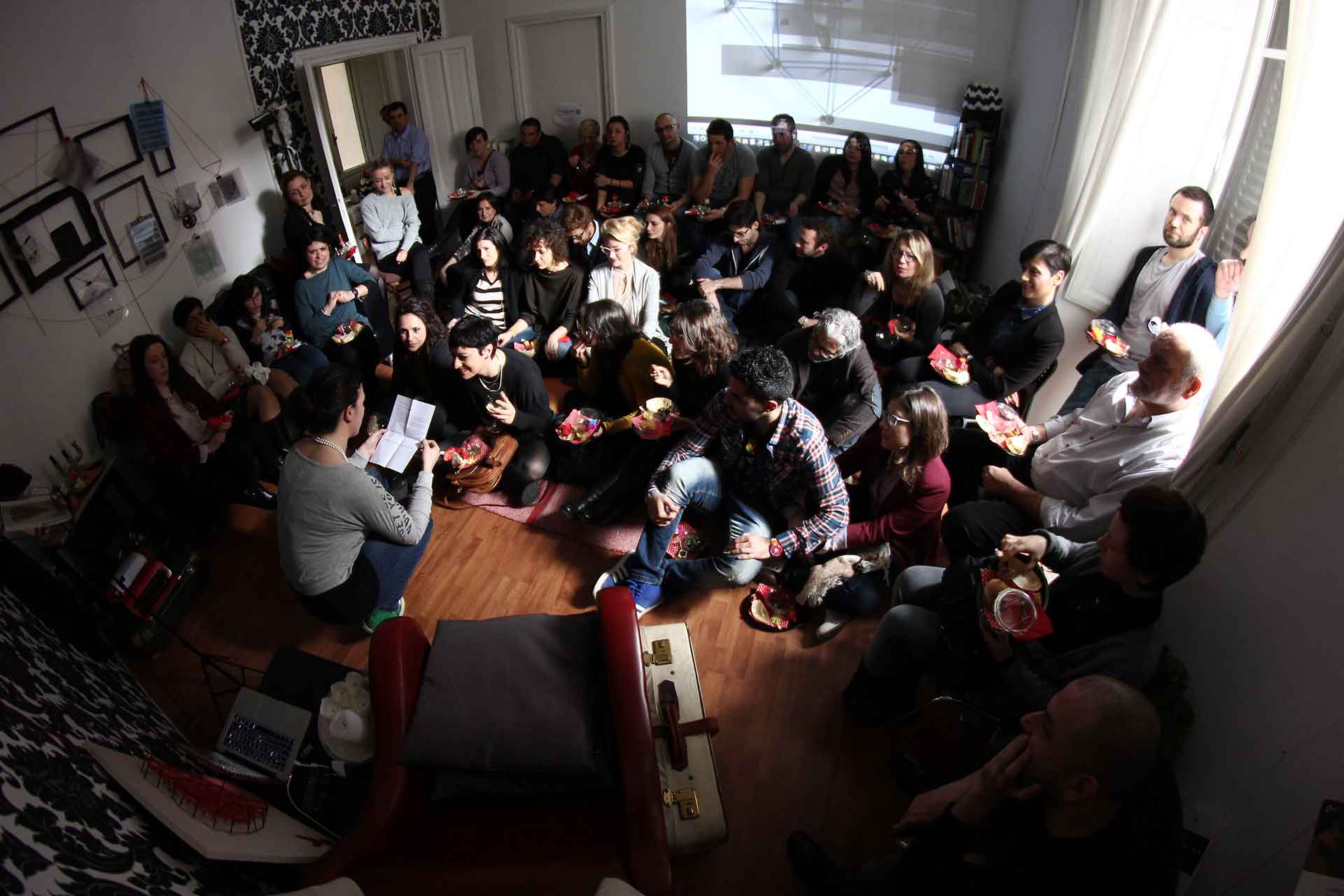 A crowded living room listening to a reading